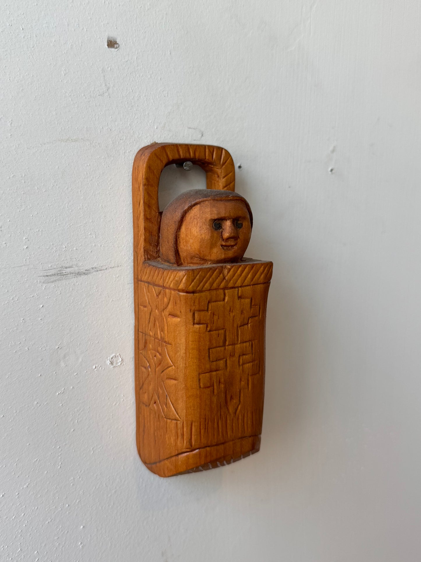 Folk carving of baby in its carrier
