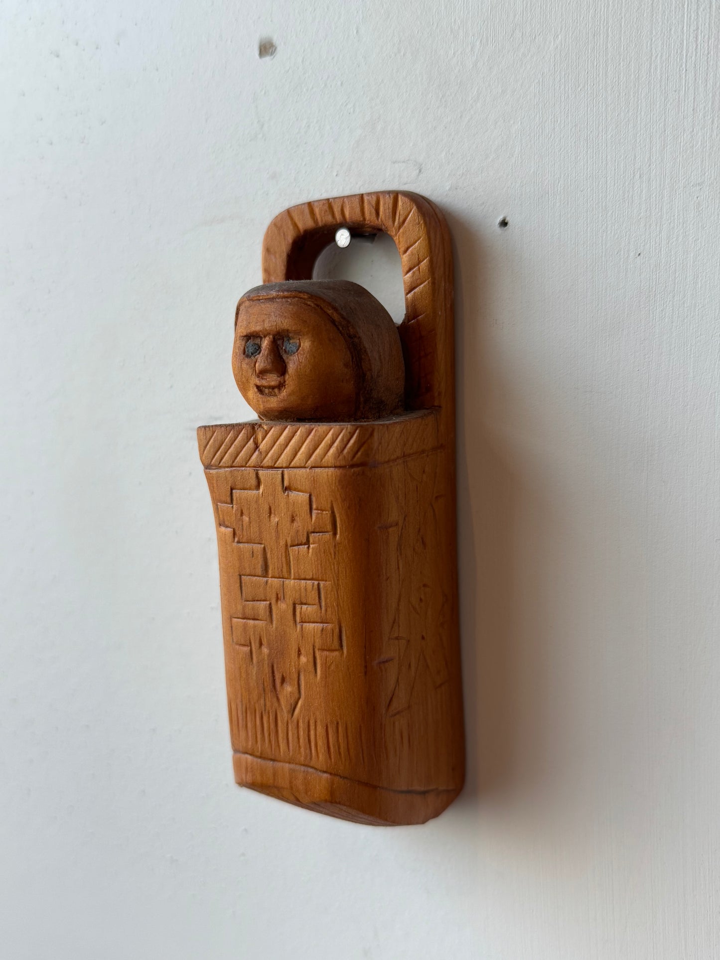 Folk carving of baby in its carrier