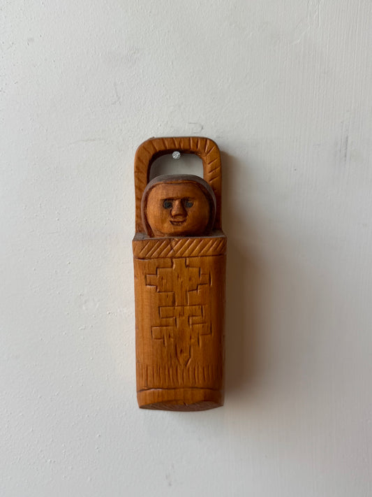 Folk carving of baby in its carrier