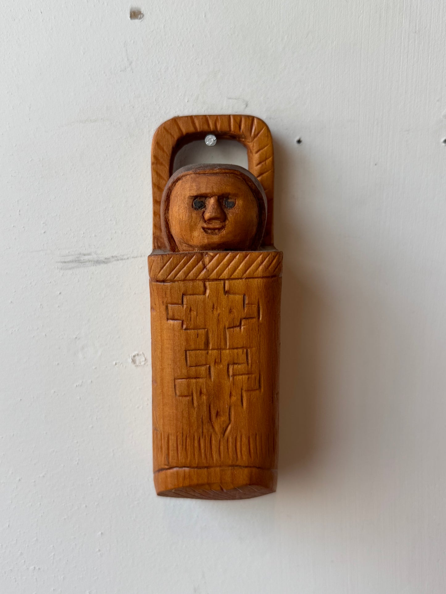 Folk carving of baby in its carrier